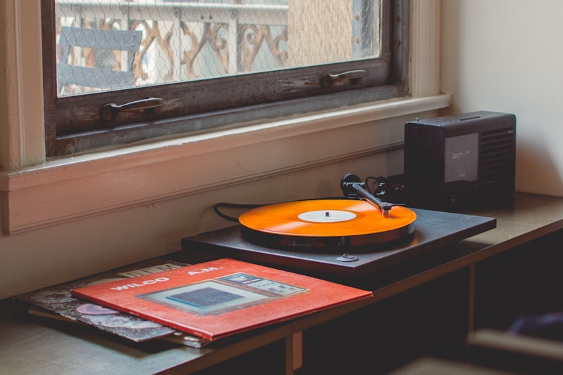 A laptop running music software next to studio monitors on a desk.